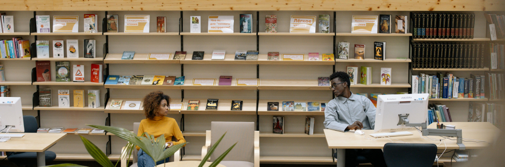 college students in library looking at laptops - Fireline Broadband