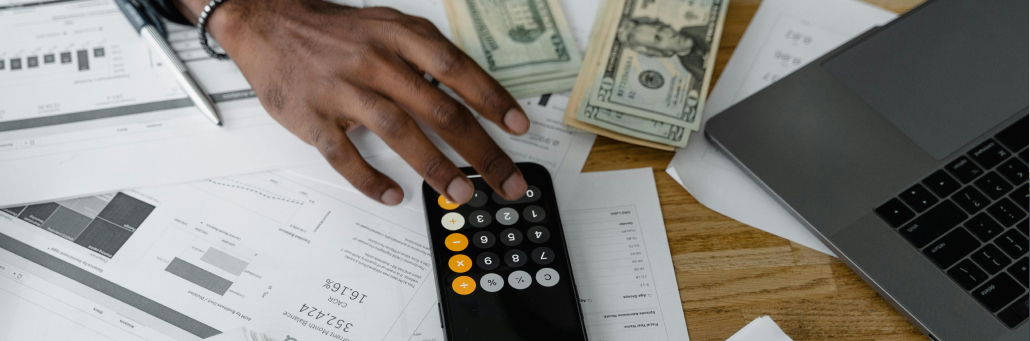 hand on calculator on top of cash and receipts - internet for finance - Fireline Broadband