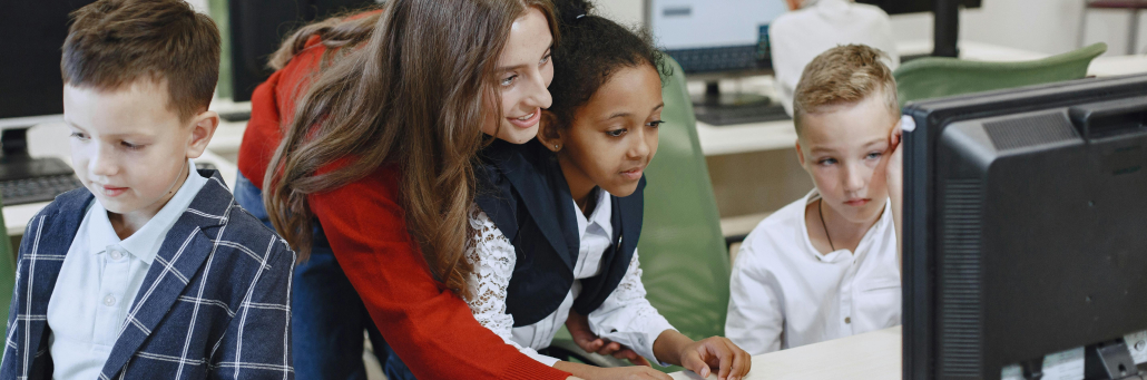 teacher helping student with an assignment using the computer - Fireline Broadband