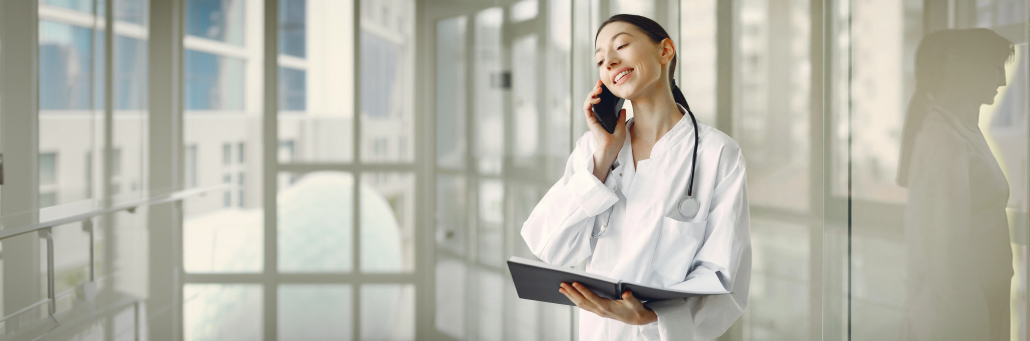 doctor on phone with laptop in hand - telehealth internet - Fireline Broadband