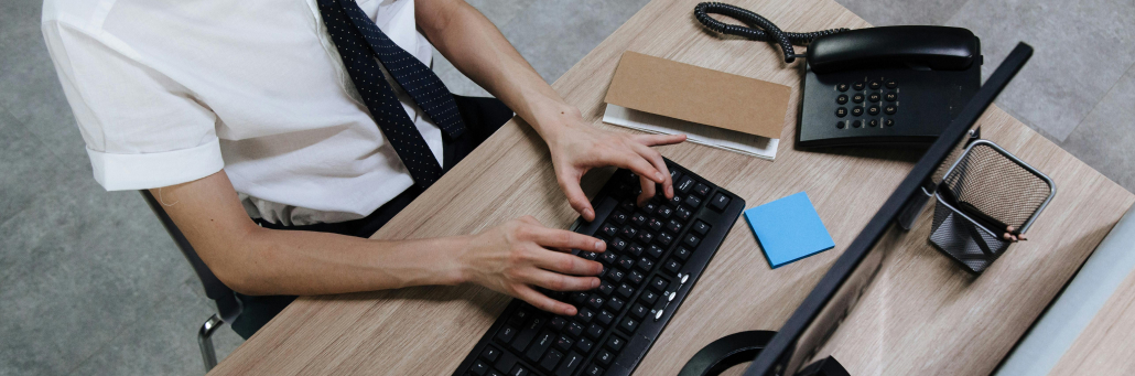 person typing on desk computer - SLA - Fireline Broadband