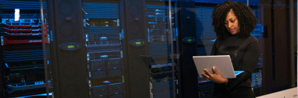 woman looking at laptop next to data center  - static ip address by Fireline Broadband
