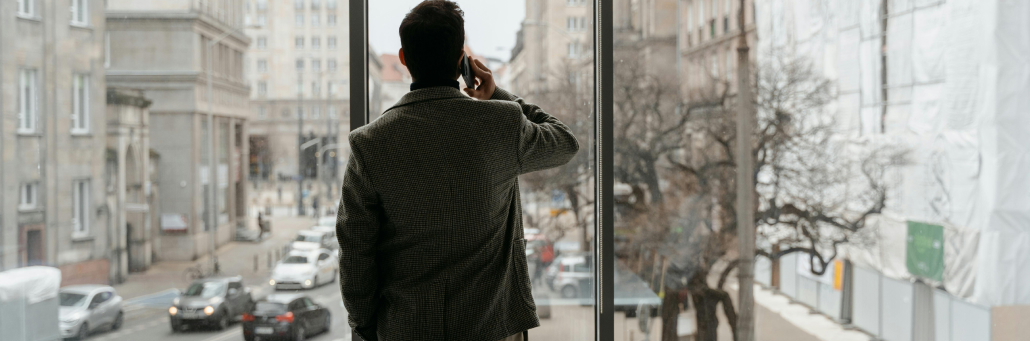 man talking on the phone while facing the window - Auto attendant - Fireline Broadband